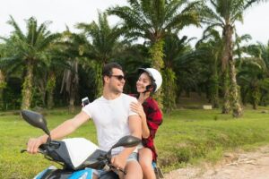 couple-riding-motorbike-young-man-and-woman-travel-on-bike-on-tropical-forest-road